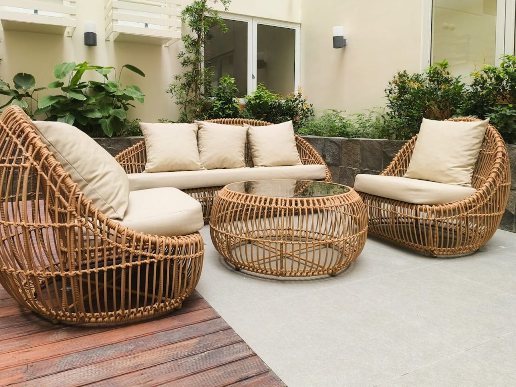 pexels photo 27975920 Outdoor seating with rattan furniture set in a lush garden patio, ideal for relaxation and gatherings.